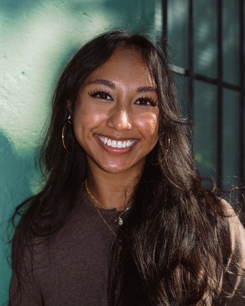 Jizel De Leon smiling in front of a green wall